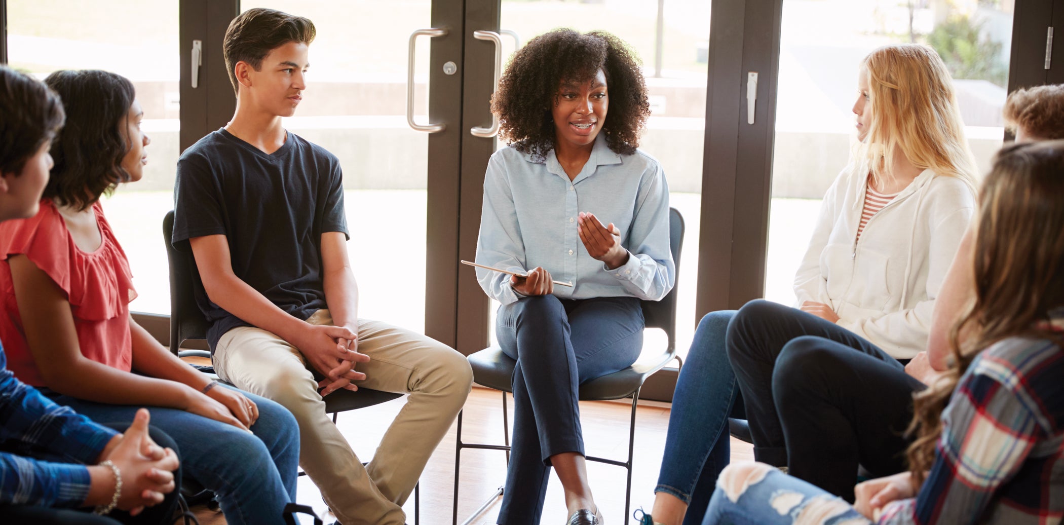 Female Tutor Leading Discussion Group Amongst High School Pupils